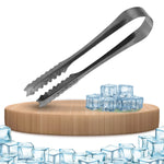 A silver tong rests on a wooden board with a small pile of ice cubes to its right, and more ice cubes below.