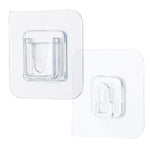 Single clear adhesive hook securely mounted on a smooth wall surface.