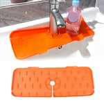 Flexible silicone sink mat positioned on a kitchen countertop to prevent water splashes.