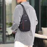 A person wears a black sling bag with red stripe and 'FASHION' label over a striped shirt, facing away.