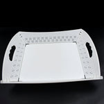 A white foldable serving tray is displayed unfolded on a black background.