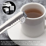 A silver tong holds a sugar cube next to a white teacup and saucer, with an inset showing two sugar cubes.