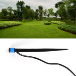 A black and blue water dripper with a thin black hose, with an upper image of a lush green park with trees and manicured