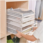Compact stack of empty clothes organizer boards, showing how they store easily when not in use.