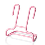 A single pink plastic shoe drying rack is shown against a plain white background with a subtle reflection.