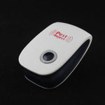 A white and black pest repeller with a black button is shown on a dark, reflective surface.