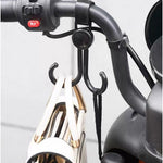 Multi-purpose stroller hook holding shopping bags and a purse on a pram.