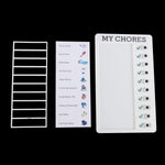 A white plastic frame, a sheet of chore icons, and the 'MY CHORES' board with green checkmarks, all on a black background.