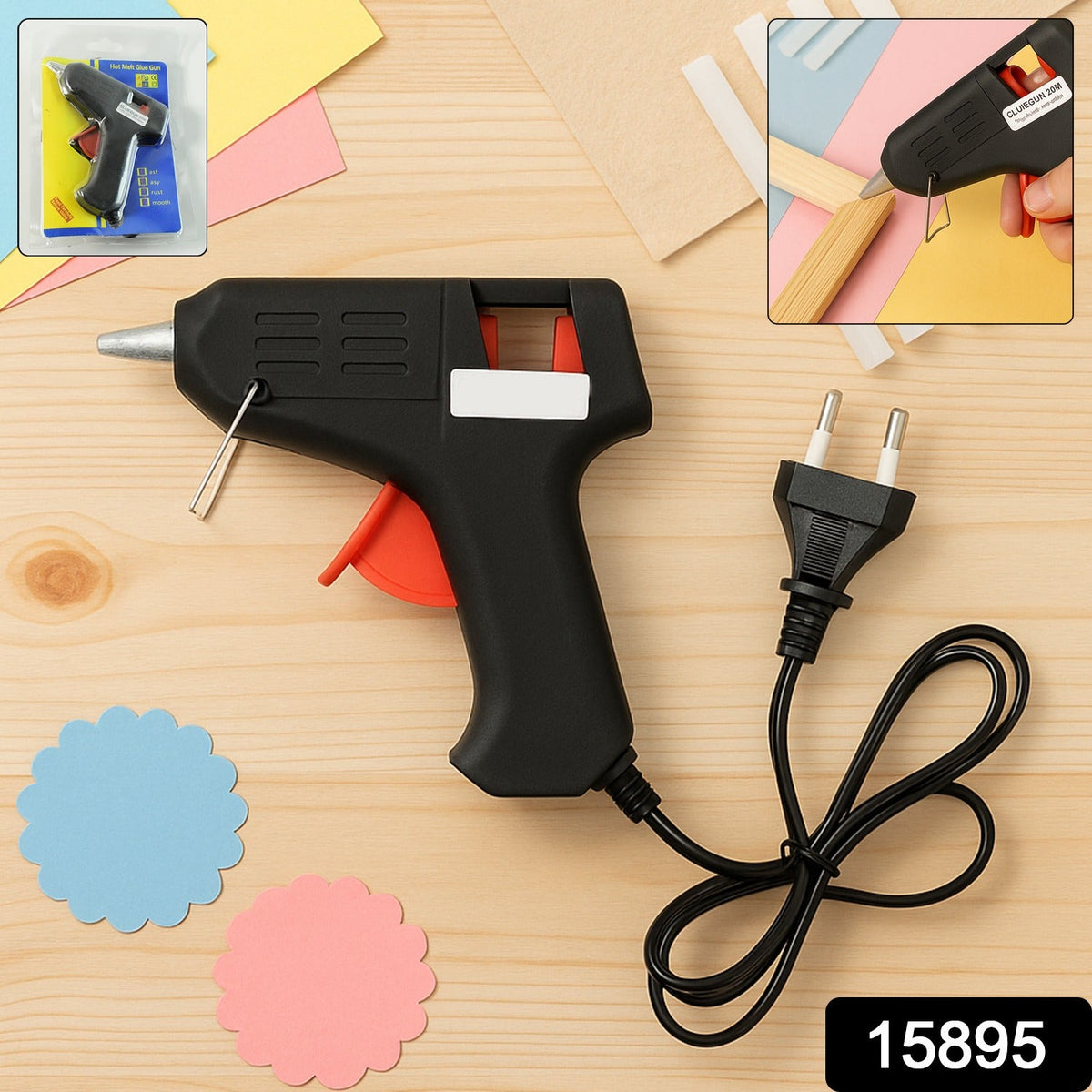A black and red glue gun with a European plug and cord, with two scalloped paper cutouts and craft paper