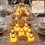 A dozen small golden lantern LED candles illuminate a rustic dining table runner adorned with autumn leaves and pumpkins.