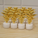 A set of twelve golden Christmas tree LED tealight candles are packaged in clear plastic on a wooden surface.
