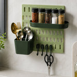 A light green pegboard with a dark green spice rack holding five spice jars, a dark green utensil holder with gold – view 8