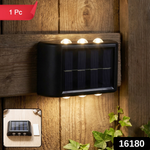 A black solar-powered LED wall light illuminates a wooden fence and green ivy at night, with a '1 Pc' label and '16180'
