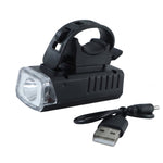 Black rectangular bicycle headlight with a clear lens and an attached USB charging cable on a white background.