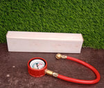Analog tire inflator gauge clearly showing its PSI and kg/cm² measurement scales.