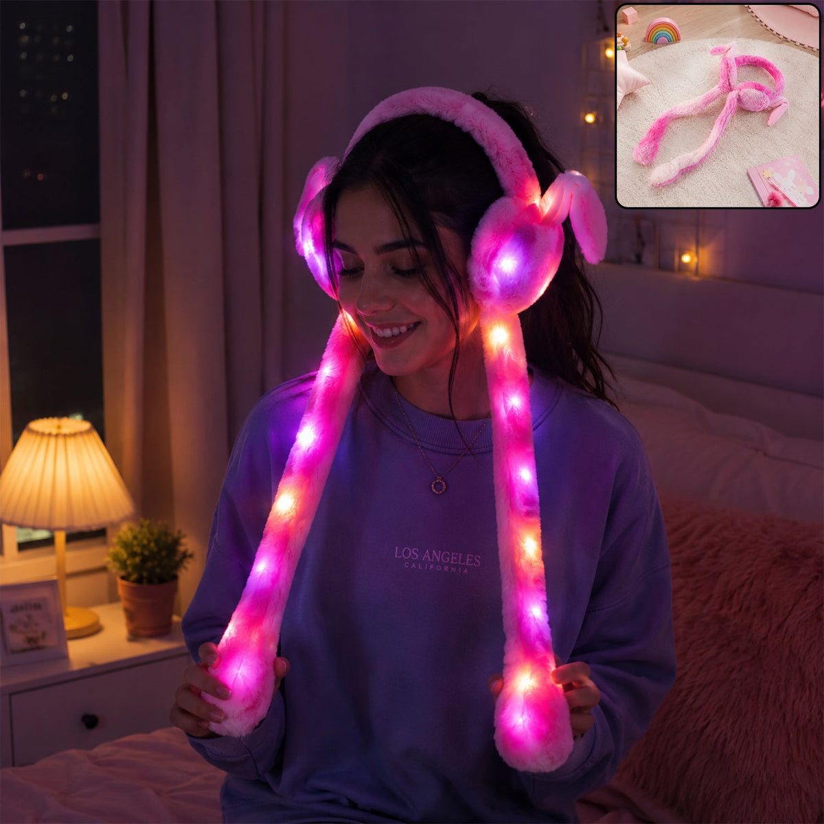 A young woman smiling while wearing pink LED light-up plush bunny earmuffs with long tails that glow brightly in dimly