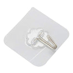 An angled, close-up view of a transparent self-adhesive hook with a silver metal hook on a white background.