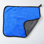 A blue microfiber cleaning cloth with a black border, folded to show its gray underside.