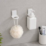 Product box for wall-mounted dispenser holders, alongside two white plastic holders and their clear adhesive pads on a