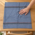 Woven cleaning cloth wiping a table