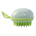 The light green silicone scalp massage brush, featuring a handle and soft bristles, is presented against a plain white