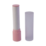 The pink and white lint roller with its clear ribbed protective case removed, on a white background.