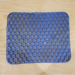 Top-down view of the blue honeycomb gel cushion on a light wooden surface.