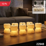 Seven glowing, ribbed, hourglass-shaped LED candles sit on a dark wood coffee table, with a small inset showing more candles.