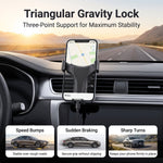 A phone in a black gravity lock car holder on a dashboard, with text