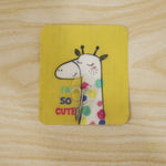 A yellow square wall hook with a cartoon giraffe and text "I'M SO CUTE" is adhered to a light wooden surface.