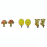 Six assorted cartoon wall hooks: two red mushrooms, two yellow smiling faces, and two sheep on skateboards, against a white