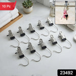 Ten metal clip hangers with black rubber tips are neatly arranged on a white marble countertop next to folded white towels