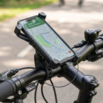 A black phone holder with a phone displaying a map is mounted on bicycle handlebars, with a small horn shown in the corner.