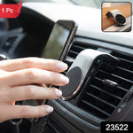 A close-up of the silver and black magnetic car phone holder on a brown textured surface.