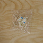 Several white plastic self-adhesive plant clips are visible inside a clear plastic bag on a light wooden surface.