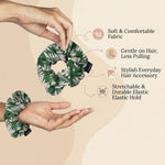 Two green and white leaf print scrunchies are held by hands, with text highlighting features like soft fabric and elastic
