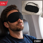 A man with a beard sleeps on an airplane wearing a black eye mask, with an inset of the mask on a pillow, and a "1 Pc" label.