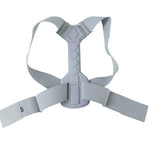 The gray posture corrector laid flat on a white background, showing the rigid central support and adjustable straps.