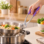 A hand holding a stainless steel pot lifter with purple handles, lifting a bowl of vegetables from a steamer.