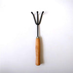 Gardener holding the hand cultivator, demonstrating comfortable grip.
