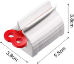 A hand turning the knob of the toothpaste squeezer to effortlessly dispense paste.