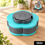 A hand rotates the light blue petal-shaped container, revealing five compartments filled with colorful dried fruit and