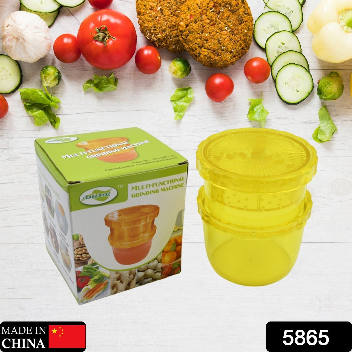 A yellow plastic manual food grinder sits next to its green and white box, labeled "Multifunctional Grinding Machine," with