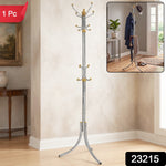 A silver-colored metal clothes hanger stand with gold accents and multiple hooks stands in a room with a painting and a side