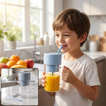 A young boy smiles while drinking orange juice from a clear portable blender with a light blue lid and straw.