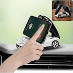 A hand interacts with a smartphone held upright in a white car-shaped phone holder on a car dashboard.