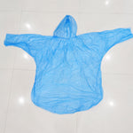 A light blue plastic poncho with a hood is spread flat on a white background, ready for use.