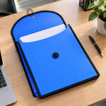 An open blue plastic document folder with white papers inside, lying on a wooden desk next to a laptop and pen.