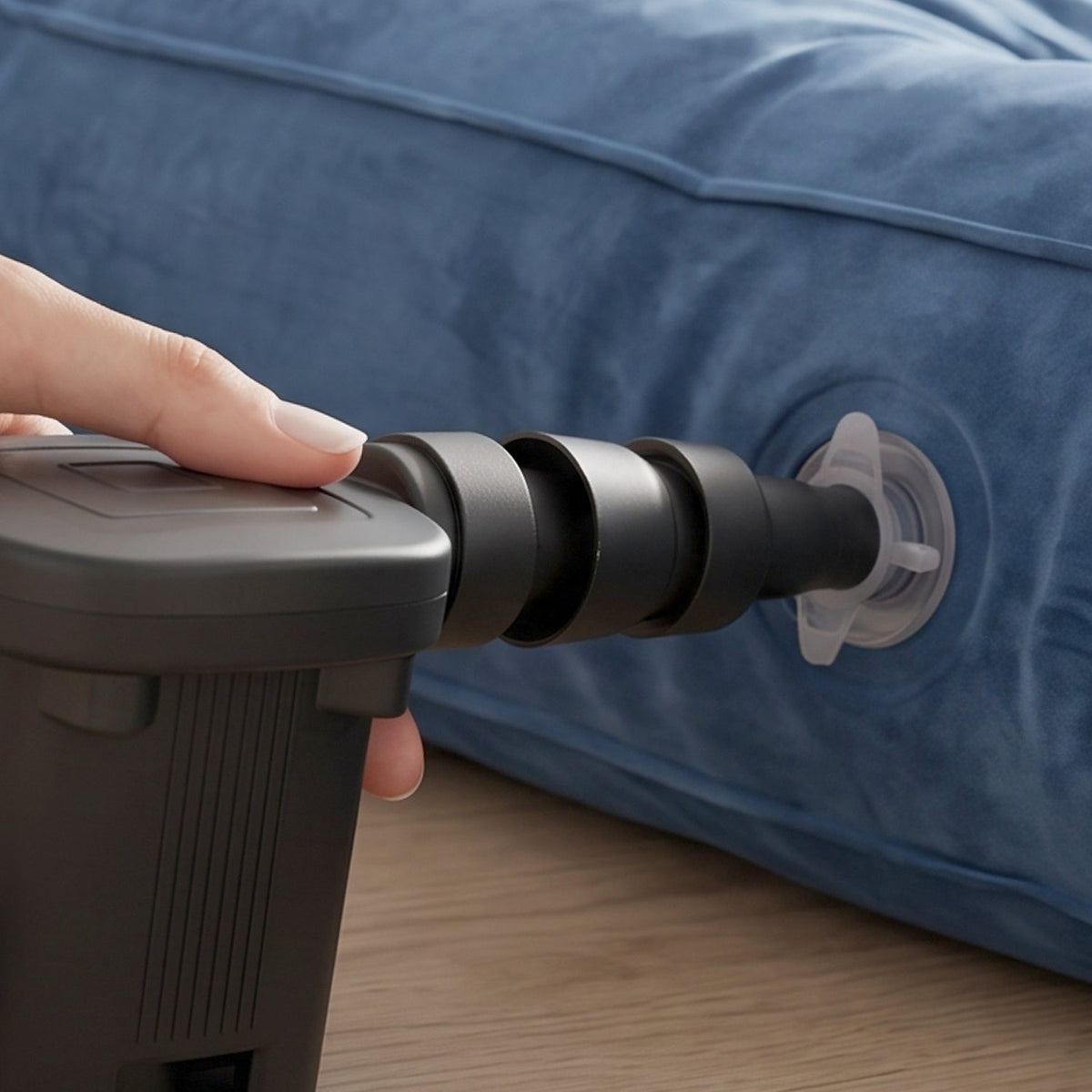 A single black multi-sized nozzle with a small loop attachment is displayed on a grey patterned surface.