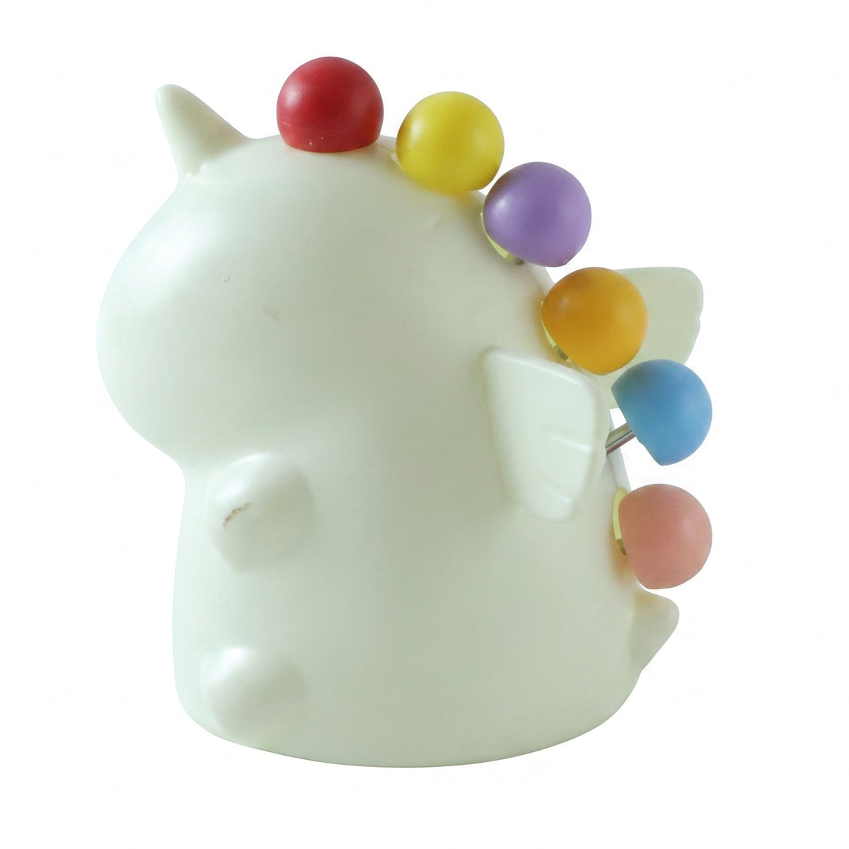A cream-colored unicorn-shaped stand with five colorful ball-tipped fruit forks inserted into its back, on a white